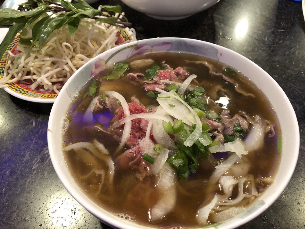 Bowl of pho with rare beef, onion and cilantro